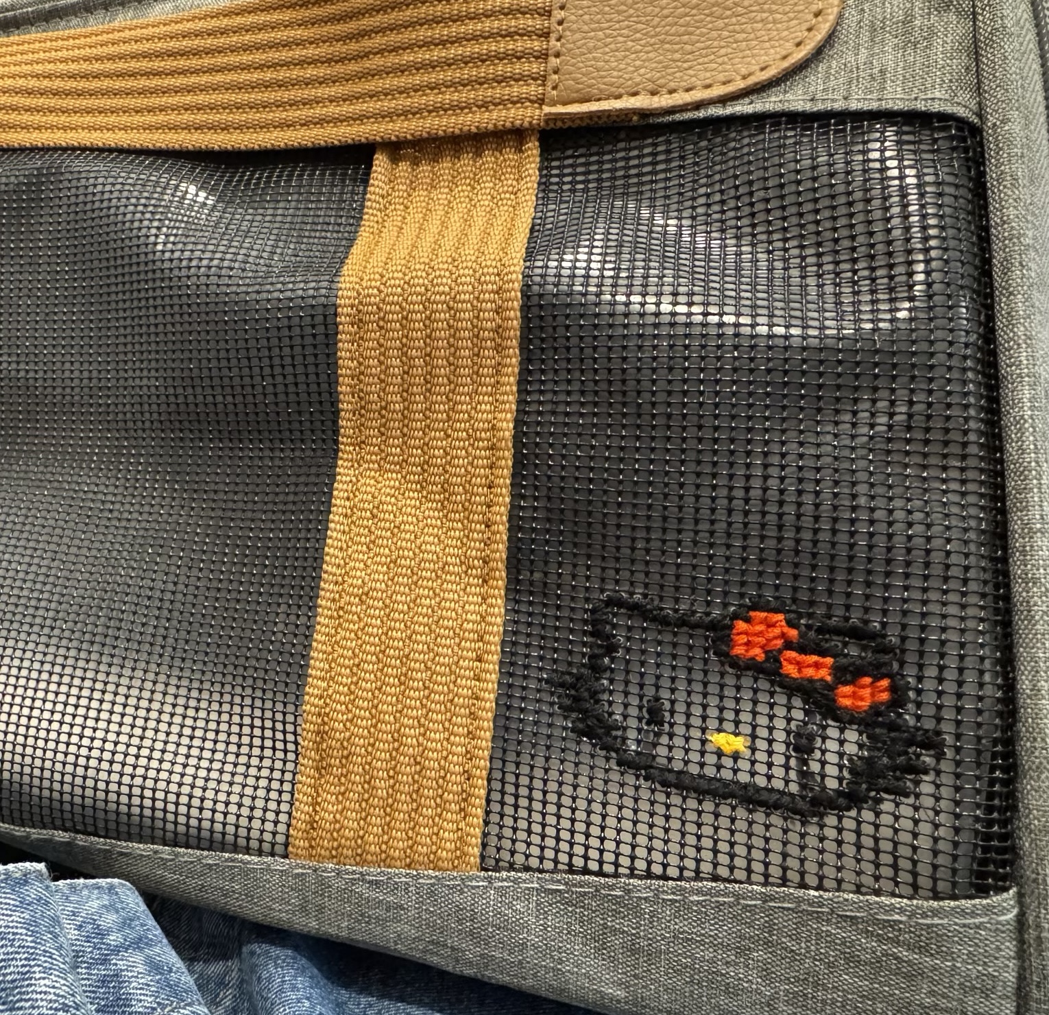 The cat carrier side panel, with a Hello Kitty face cross-stitched onto it.