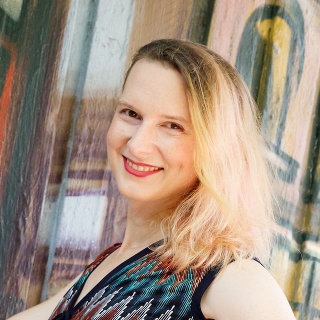 Photo from the shoulders up of Elora smiling at the camera.